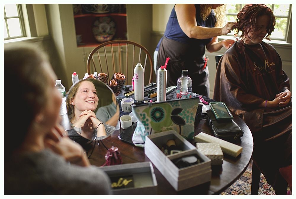 Couple holding hands, walking through a grassy field. Trees in the background. Black and white photo.