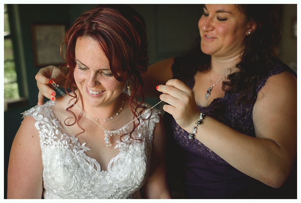 Couple embraces under a large tree. The woman has long blonde hair, the man has a beard.