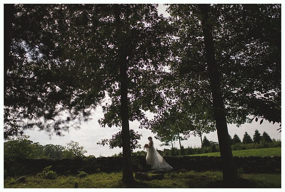 Woman embraced from behind; arms crossed, wearing bracelets.