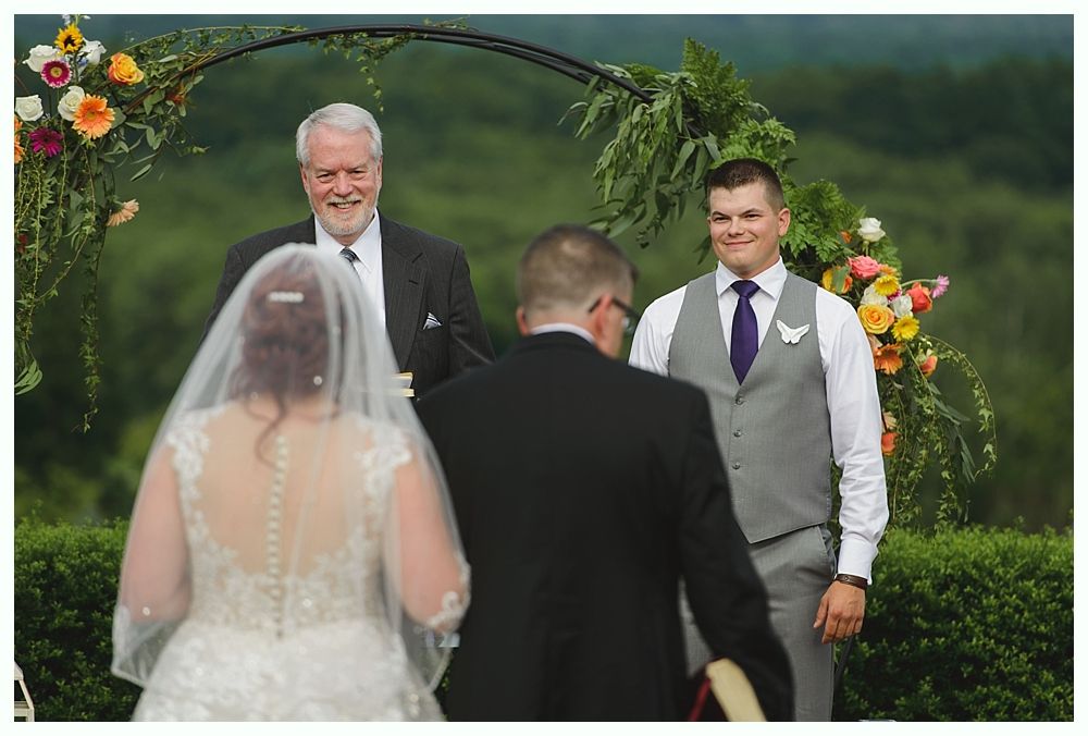 Couple embracing under a large tree in a foggy outdoor setting.