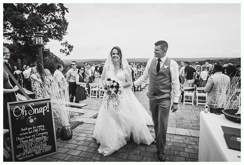 Diamond engagement ring on yellow flower in tall grass.