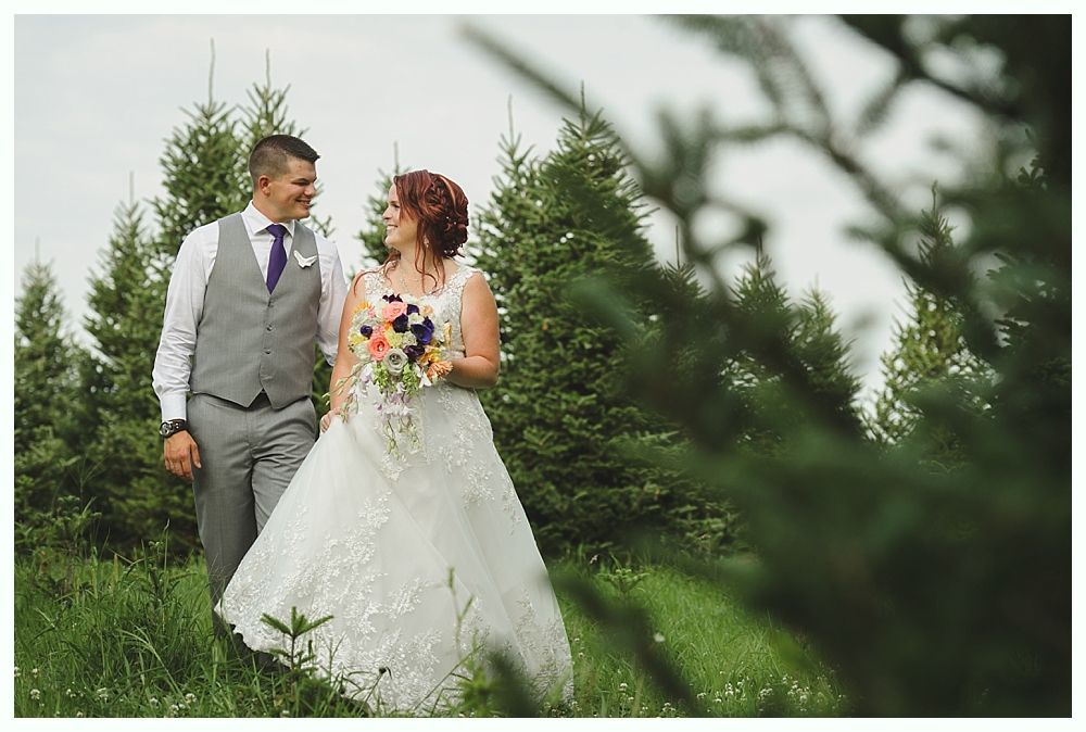 Diamond engagement ring on yellow flower in tall grass.