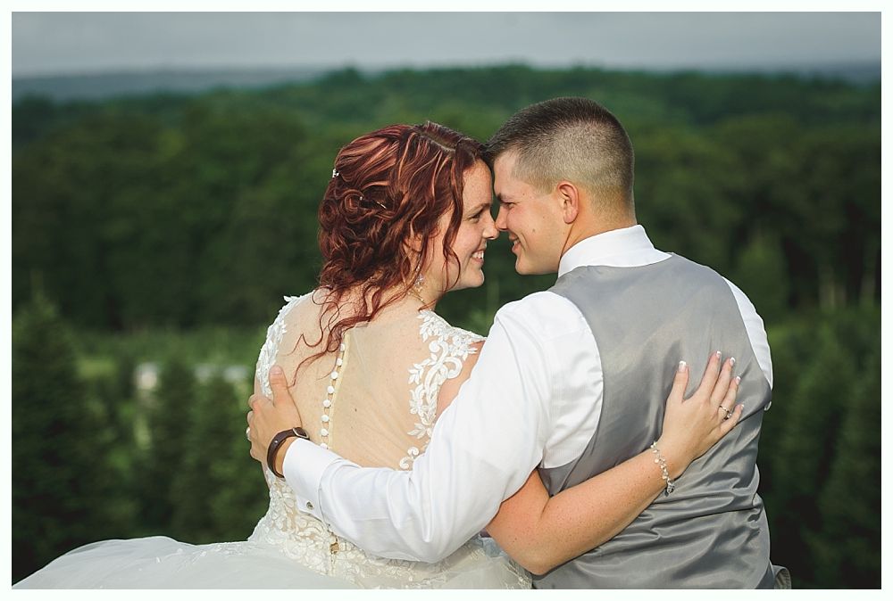 Diamond engagement ring on yellow flower in tall grass.