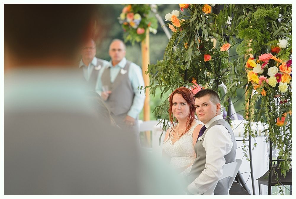 Diamond engagement ring on yellow flower in tall grass.