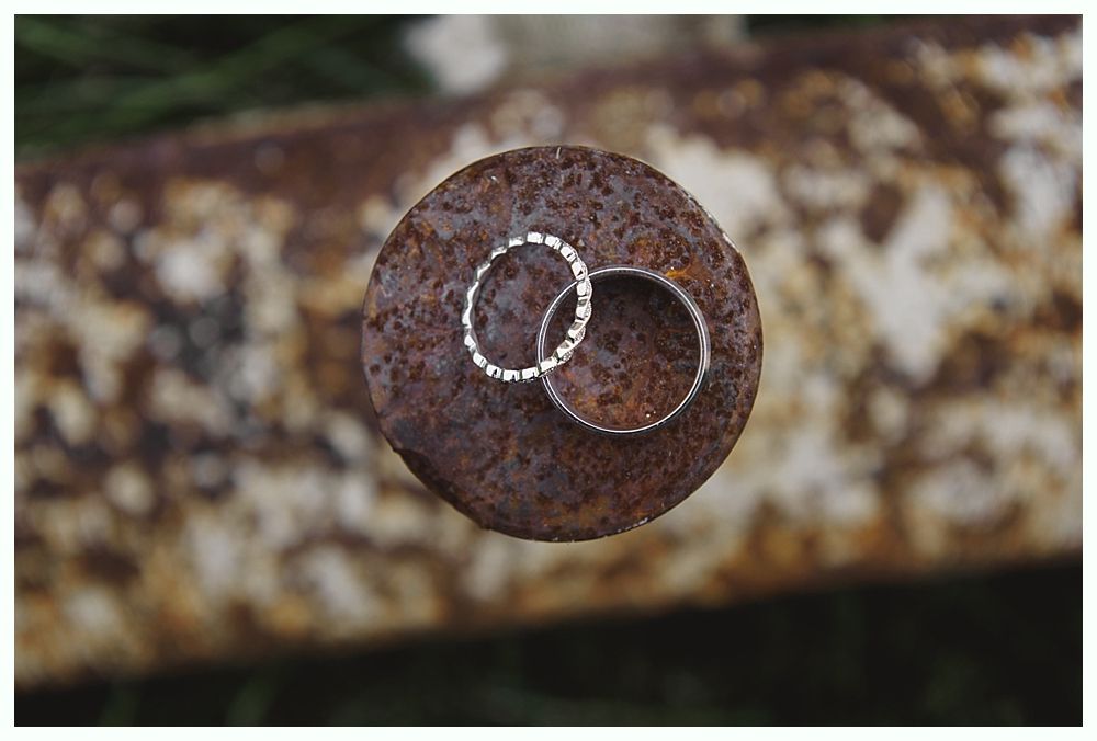 Diamond engagement ring on yellow flower in tall grass.