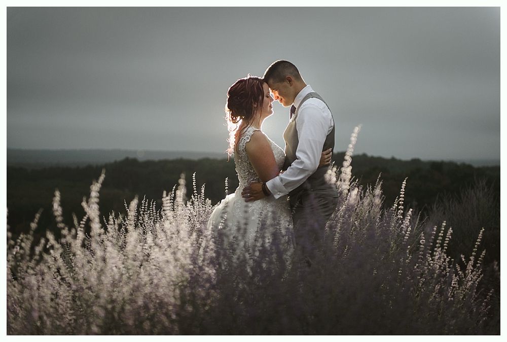 Diamond engagement ring on yellow flower in tall grass.