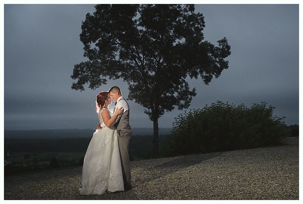 Diamond engagement ring on yellow flower in tall grass.