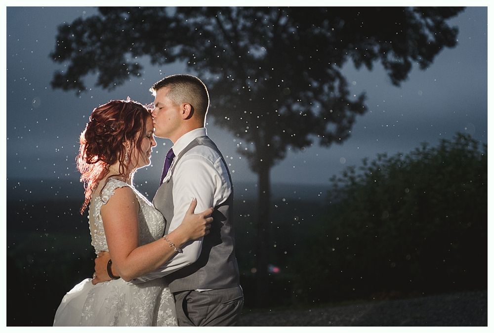 Diamond engagement ring on yellow flower in tall grass.