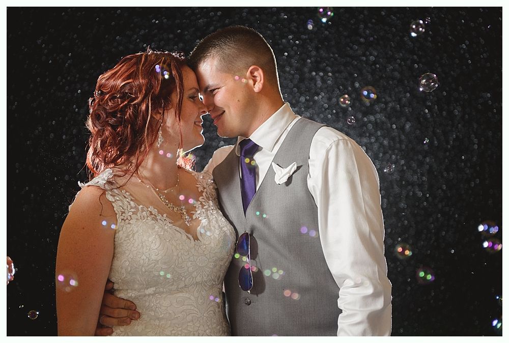 Diamond engagement ring on yellow flower in tall grass.