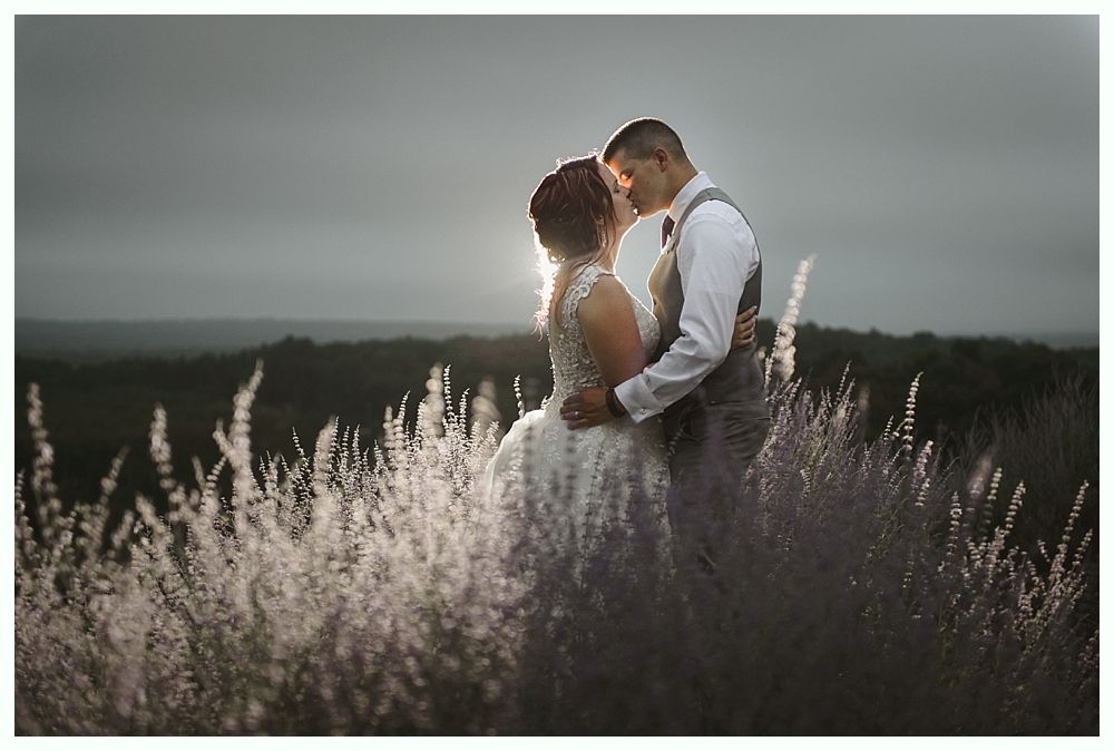 Diamond engagement ring on yellow flower in tall grass.