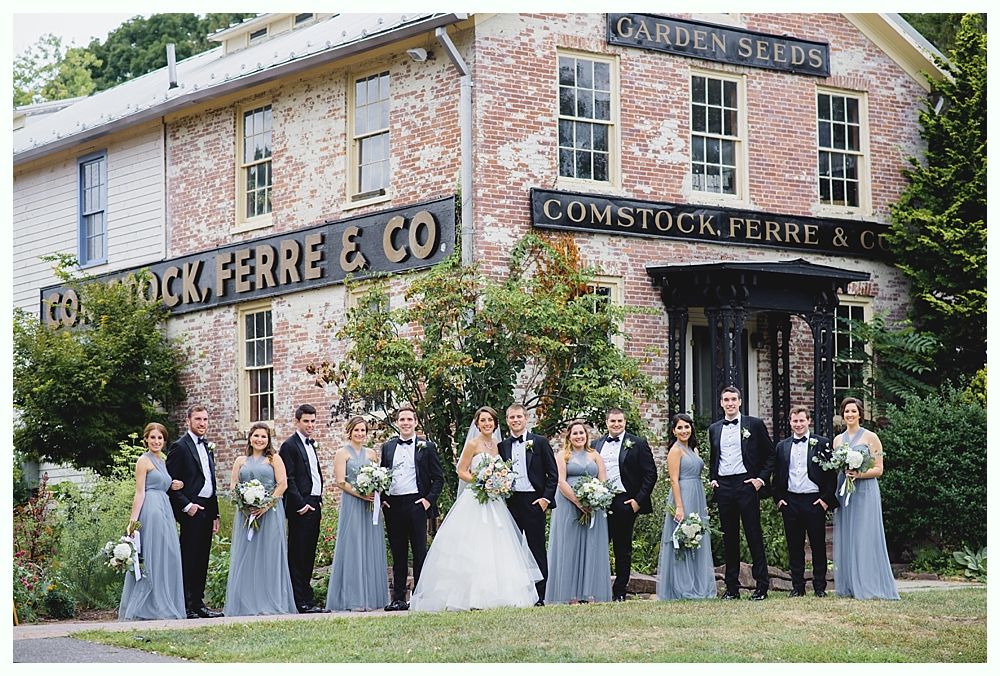 Wedding party poses outside a brick building with 