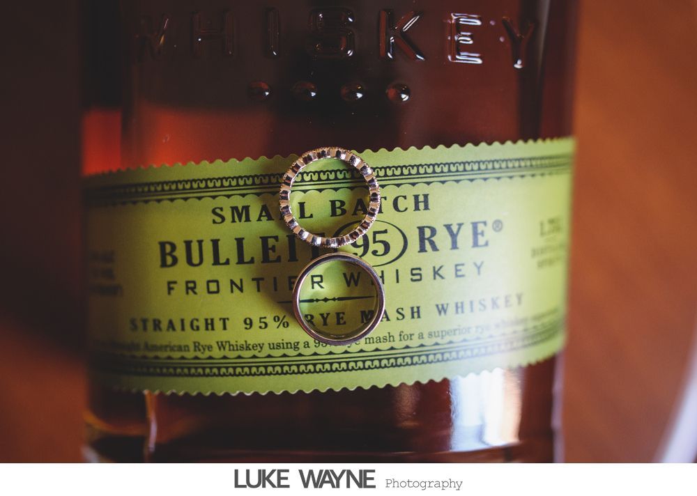 Two wedding rings rest on a Bulleit Rye whiskey bottle label.