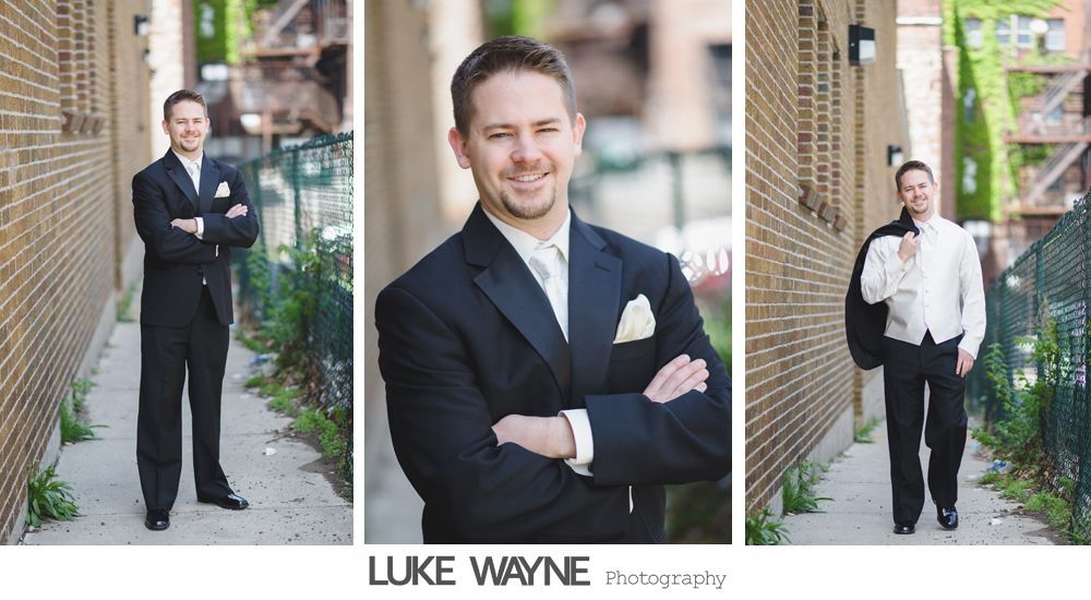 Man in tuxedo posing outdoors with brick wall background.