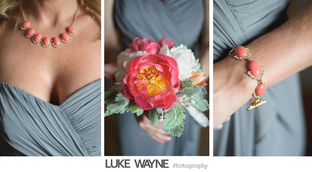 Woman in gray dress, coral jewelry, and bouquet with pink and white flowers.