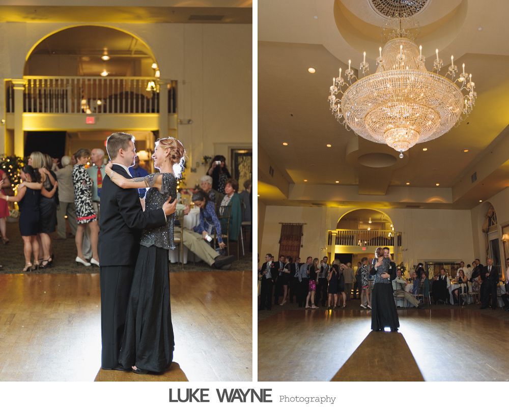 Couple dances at a wedding reception. Grand chandelier and guests in a large ballroom with warm lighting.