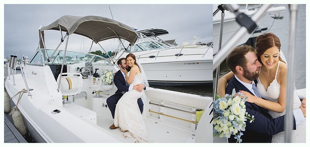 A newly married couple on a boat, the woman in a white dress, the man in a navy suit, smiling and embracing.