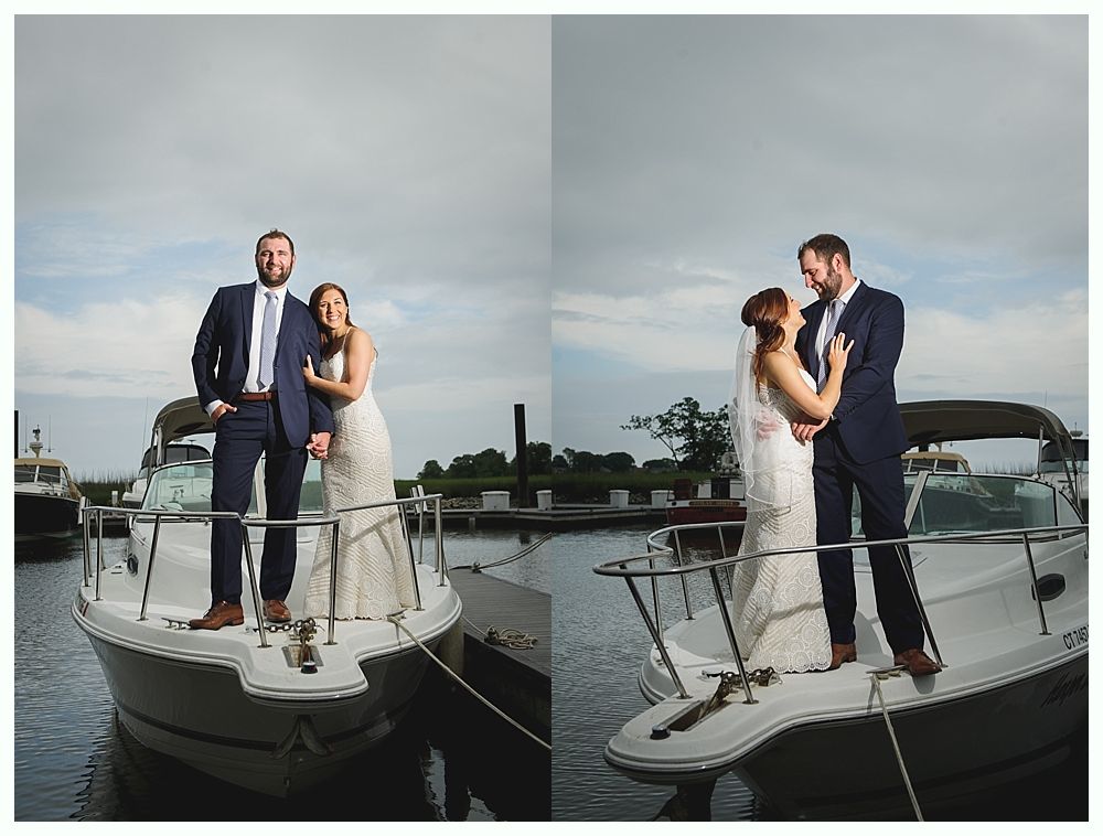 Couple in wedding attire on a boat, posing for photos. Cloudy sky, harbor background.