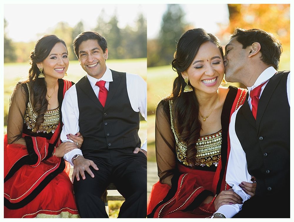 Couple in formal attire; the woman in a red sari, the man in a vest and tie; outdoors.
