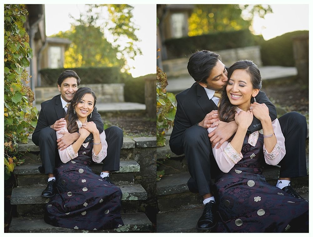Couple sitting on steps, posing. Man kisses woman's cheek. Both smiling, wearing formal attire outdoors.