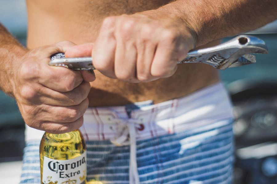 Bride in a white strapless gown adjusts her earring, then smiles holding sunflowers; indoors, window light.