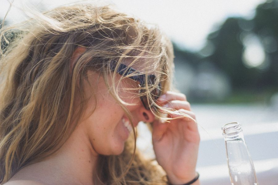 Wedding party toasting with beer bottles in an outdoor setting; sunflowers and smiles.
