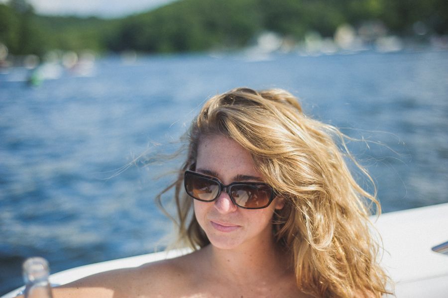 Bride and groom kissing amidst trees, holding bouquets. Black and white photo.