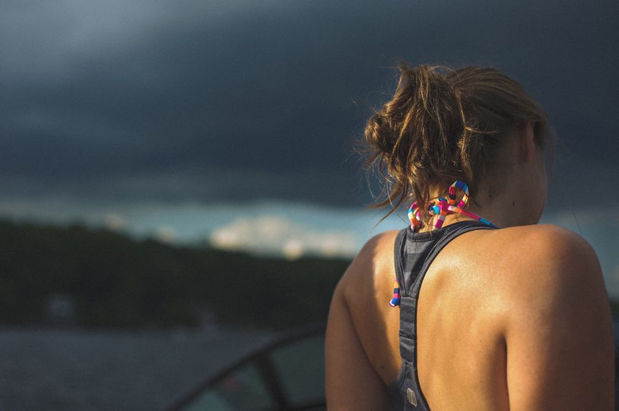 Bride and groom embracing, silhouetted under a large tree, in black and white.