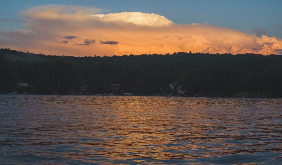 Person taking photo in mirror, indoors; black and white.