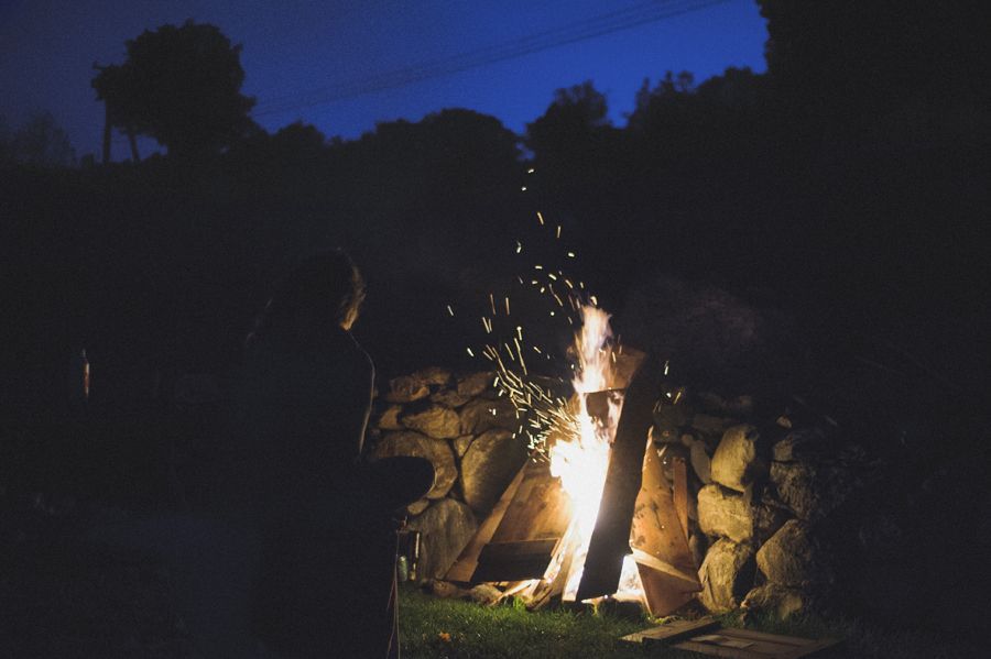 Person taking photo in mirror, indoors; black and white.