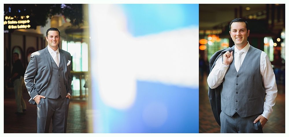 Man in gray suit with a white shirt smiles at the camera, posing indoors.