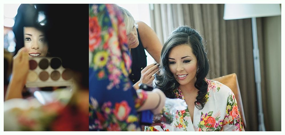 Woman getting makeup done before an event. She wears a floral robe.