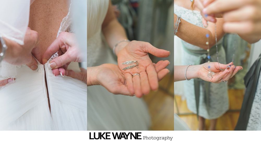 Woman in teal dress helping another woman fasten her white wedding dress.