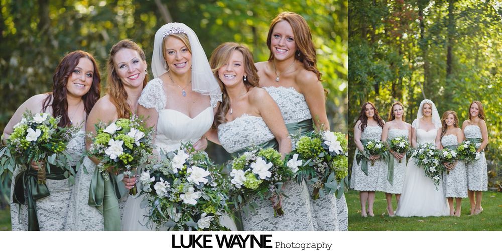 Couple in wedding attire walk through a sunny orchard.
