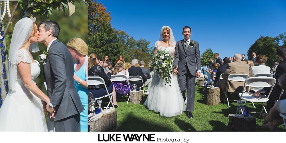 Bride and groom walking down aisle after outdoor wedding ceremony. Guests watch.