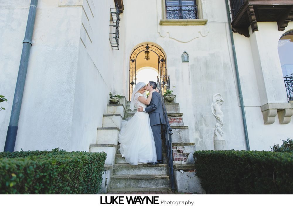 Couple dances at a wedding reception; guests watch. Black and white.