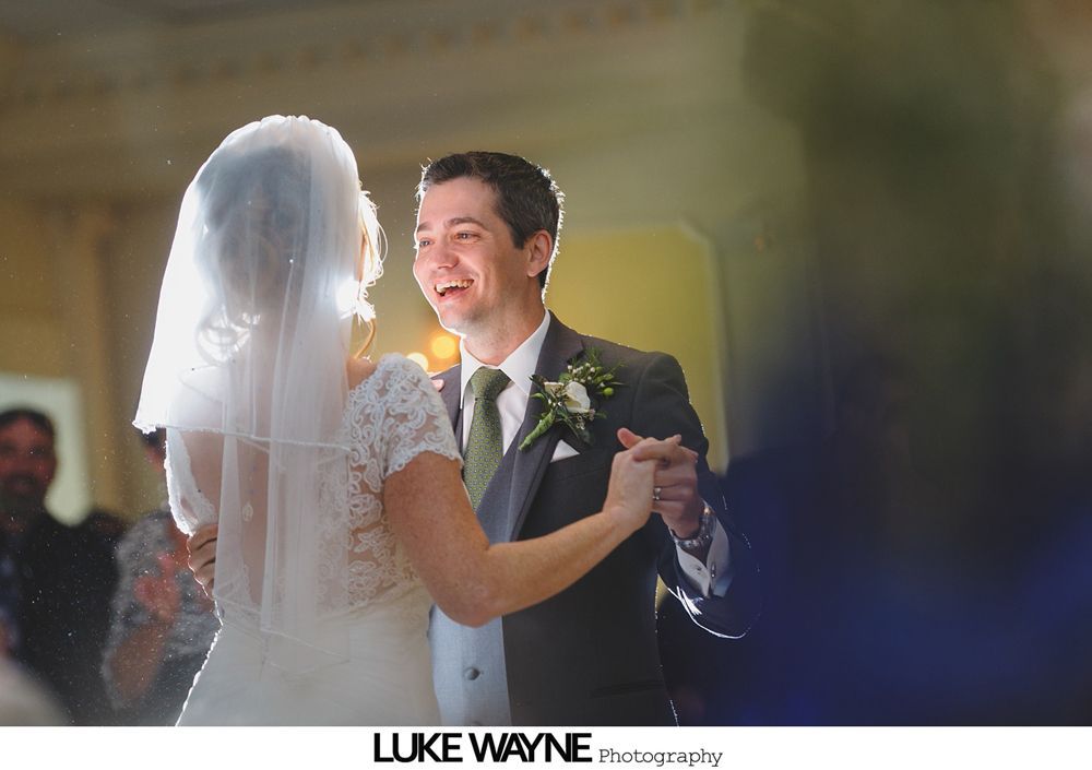 Wedding reception with dancing; bride in a white gown and guests in colorful dresses on a dance floor.