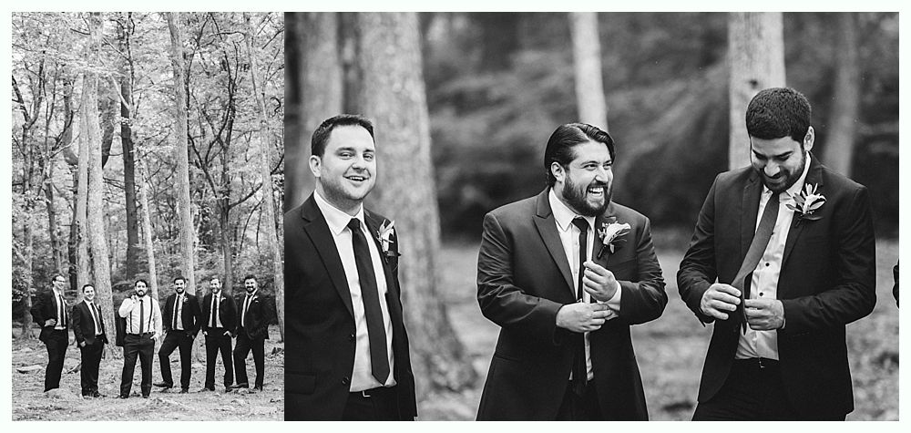 Groomsmen in suits adjusting ties in a forest, black and white photograph.