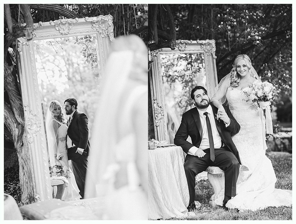 Bride and groom pose near ornate mirrors, one side shows their reflection, other shows them looking at the camera.