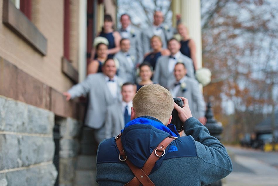 Bride and bridesmaids in navy dresses hold bouquets, posing outdoors.