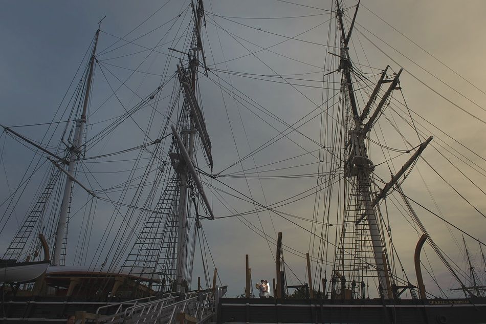 Tall ship's masts and rigging silhouetted against a cloudy sky.