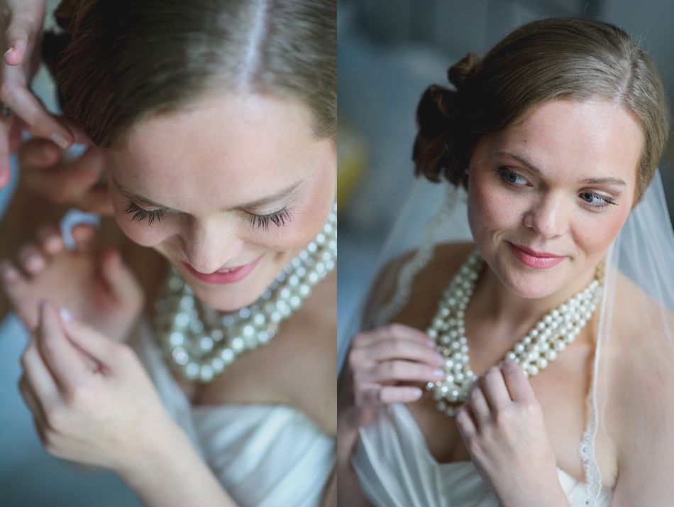 Bride wearing layered pearl necklace, adjusting it while looking down, getting ready for the wedding.