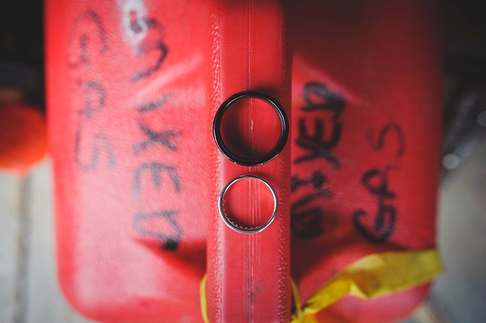 Two rings, one black and one silver, on a red gas can labeled