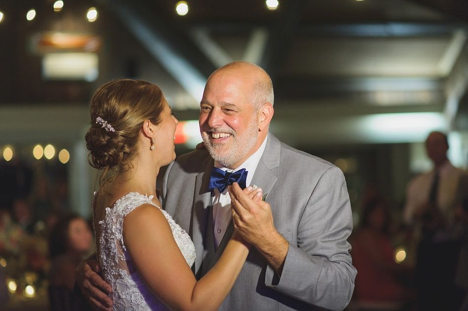Bride and father share a joyful dance at a wedding reception.