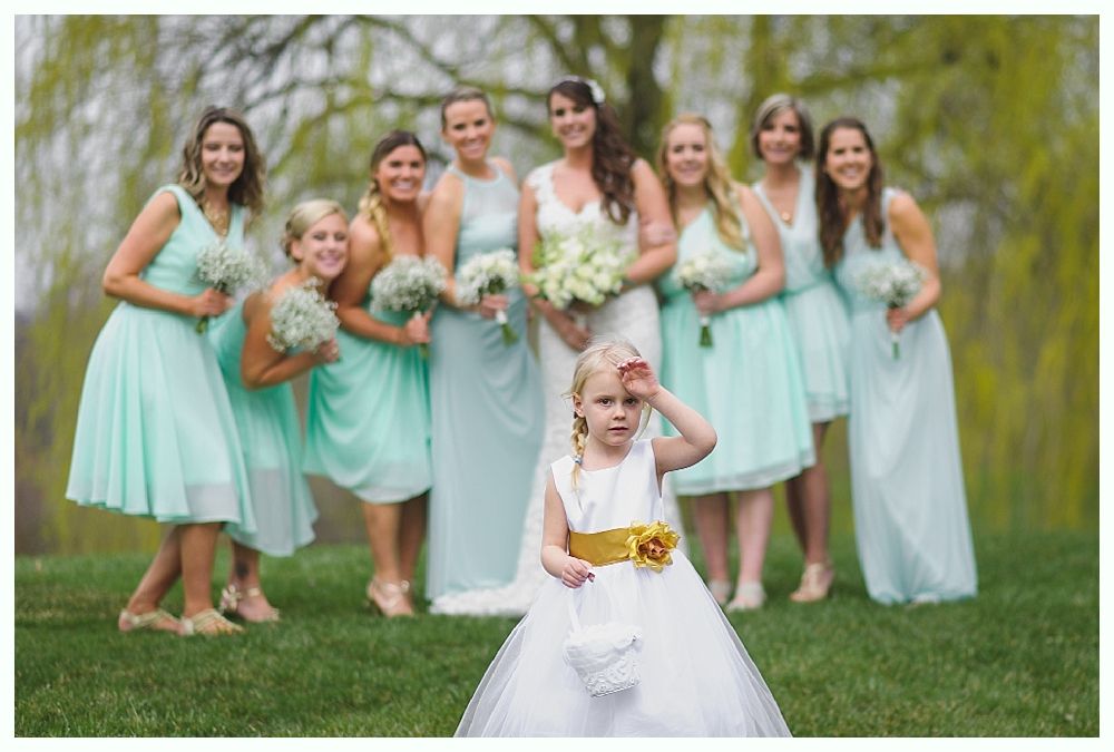 Wedding party with bride and bridesmaids in teal dresses, flower girl in white dress.