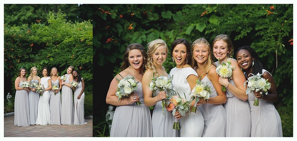 Bridesmaids smiling, holding bouquets, in gray dresses, in front of greenery.