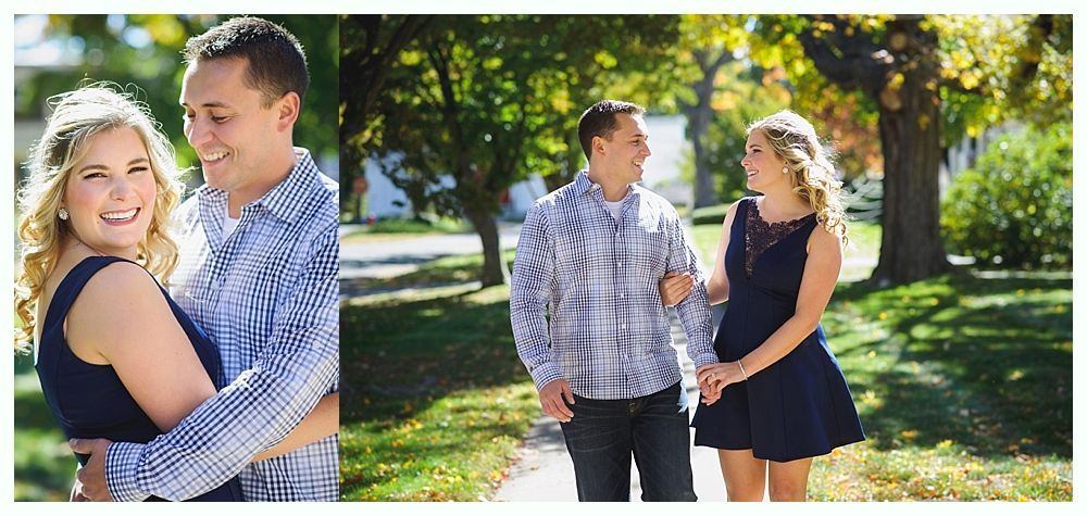 Couple smiling and walking on a path, trees in the background, daytime.