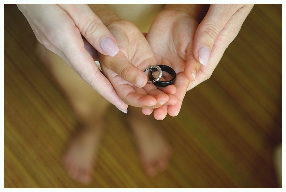 Hands holding wedding rings.