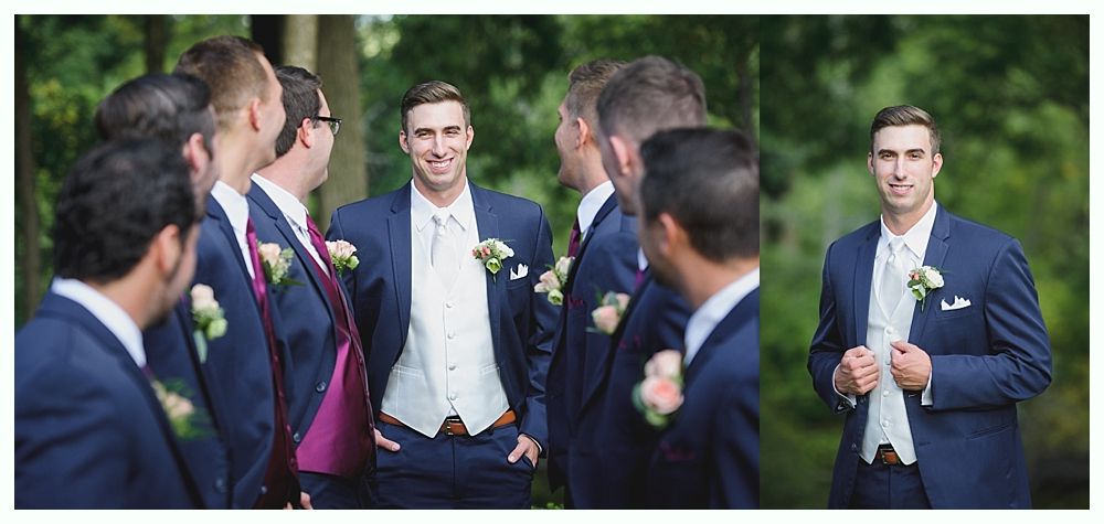 Group of men in suits posing outside. The center man is smiling, others are looking.