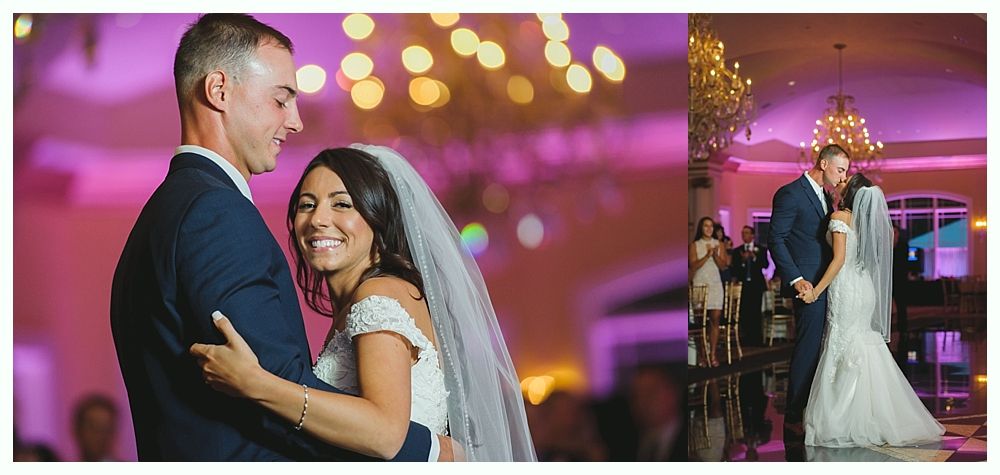 A couple dances at their wedding reception. The bride smiles, the groom embraces her.