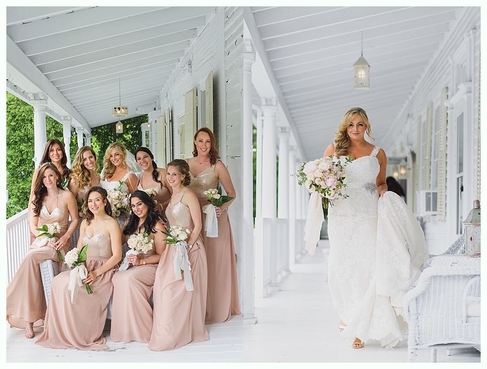 Bride with bridesmaids on a white porch; bride in lace gown, bridesmaids in pink gowns.